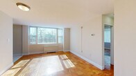 Located at 1845 Summit Pl NW in Washington, DC's vibrant Adams Morgan neighborhood, this sixth-floor one-bedroom, one-bathroom unit offers a well-organized layout across a single level. Warm parquet hardwood flooring flows throughout the living areas and bedroom, adding a classic character to the interior. The living room is bright and inviting, featuring large windows fitted with vertical blinds that frame tree-lined outdoor views and allow generous natural light to fill the space.

The kitchen is efficiently designed, featuring rich cherry wood cabinetry extending to the ceiling for ample storage, stainless steel appliances including a gas range, built-in microwave, and refrigerator, complemented by light ceramic tile flooring and a pendant light fixture overhead.

The bedroom is a comfortable size, offering a double-door closet for storage, a window for natural light, and the same warm parquet flooring found throughout. The bathroom features a full soaking tub with a shower combination, finished with neutral beige ceramic tile surround and clean white fixtures, providing a straightforward and functional space. The unit's neutral color palette and consistent flooring create a cohesive, light-filled ambiance throughout.