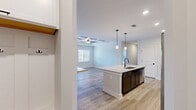 Located at 1220 Strensall Ln in Charlotte, NC, this well-appointed single-story home offers three bedrooms, two bathrooms, and three closets within a thoughtfully designed floor plan. The open-concept living and kitchen area serves as the heart of the home, where light-toned luxury vinyl plank flooring flows seamlessly underfoot. A coffered ceiling with a ceiling fan adds architectural character to the living space, which is brightened by natural light from a large window.

The kitchen is a standout, featuring a central island with a granite countertop and undermount sink, complemented by two-tone cabinetry — crisp white uppers and dark espresso lowers — set against a classic subway tile backsplash. Stainless steel appliances complete the modern aesthetic.

The primary bedroom is generously sized, finished with plush carpet and a ceiling fan, and offers direct access to both a walk-in closet with wire shelving systems and a private en-suite bathroom. The bathrooms are finished with granite-topped dark vanities, wood-look tile flooring, and matte black hardware and fixtures, creating a cohesive, contemporary look. Additional bedrooms are well-proportioned and carpeted, each served by their own closet storage. The overall ambiance is clean, modern, and move-in ready.