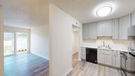 Located at 1002 Mayflower Dr in Wilmington, NC, this one-bedroom, one-bathroom unit offers a practical and well-appointed single-floor layout. Throughout the space, wood-look plank flooring provides a cohesive and low-maintenance foundation, complemented by neutral warm-toned walls and textured ceilings.

The kitchen is a standout feature, showcasing gray shaker-style cabinetry that extends to the upper walls for ample storage, marble-look countertops, a stainless sink, and a suite of black appliances including a refrigerator, dishwasher, and range. The kitchen connects seamlessly to a hallway that links the main living areas.

The living room is bright and open, benefiting from a full sliding glass door that invites natural light and provides direct access to an outdoor patio area. The bedroom offers a comfortable footprint with a large reach-in closet featuring built-in shelving and hanging rods on both sides, as well as an additional standard closet. A window allows natural light to fill the room.

The bathroom includes a full tub-shower combination with built-in corner shelving and clean white surround walls. A dedicated hallway connects all rooms, contributing to a functional and efficient flow throughout this cozy Wilmington residence.
