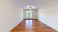Located at 505 Vorils Ln in Wilmington, NC, this well-appointed 2-bedroom, 2-bathroom single-floor residence offers a thoughtfully designed layout across a comfortable footprint. The open-concept living and kitchen area serves as the heart of the home, featuring warm hardwood flooring that flows throughout the main living spaces. The kitchen is equipped with rich dark-wood cabinetry, granite countertops, a full suite of stainless steel appliances including a refrigerator, range, built-in microwave, and dishwasher, and a peninsula with pendant lighting that provides additional prep and seating space. The living room is bright and airy, with a ceiling fan and French doors that open to a private balcony overlooking lush greenery. Both bedrooms are carpeted for comfort and receive natural light through window treatments. The spacious primary bedroom includes a walk-in closet with wire shelving. The bathrooms are finished with dark-wood vanities and one features a soaking tub with an overhead shower combo and brushed nickel fixtures. Two hallways connect the spaces efficiently, and a dedicated closet adds further storage. Neutral wall tones throughout create a clean, versatile atmosphere.