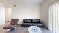 Located at 755 Burcham Dr in East Lansing, Michigan, this three-bedroom, three-bathroom single-floor unit offers a clean, modern aesthetic with consistent wood-look flooring and a neutral color palette throughout. The kitchen is a standout feature, boasting white shaker-style cabinetry with glass-front upper panels, a classic white subway tile backsplash, light quartz countertops, matte black hardware, and a full suite of stainless steel appliances including a range, over-the-range microwave, dishwasher, and refrigerator. The combined kitchen and living room forms a functional shared space, where the living area accommodates comfortable seating alongside a wall-mounted TV and dining table. Each of the three bedrooms is well-proportioned, featuring wood-look flooring, natural light from large windows with blinds, and ceiling fans for added comfort. The primary bedroom includes mirrored sliding closet doors, enhancing the sense of space and light. Each bedroom also offers a dedicated desk and chair setup, ideal for studying or remote work. The three bathrooms maintain the home's clean design with white cabinetry, light countertops, and matte black fixtures. A central hallway connects all rooms, providing a practical and efficient layout throughout the space.