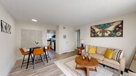 This two-bedroom, two-bathroom residence in Memphis, Tennessee is laid out across a single floor, offering a functional and comfortable living arrangement. Wood-style plank flooring runs throughout, providing a cohesive look that ties each room together.

The open living and dining area is bright and welcoming, featuring a large window with vertical blinds that allows natural light to fill the space. A textured ceiling adds subtle character, while neutral walls keep the aesthetic clean and versatile.

The kitchen is a standout feature, showcasing white cabinetry, dark countertops, and a bold marble-look tile backsplash. Black appliances, including an electric range, complement the contrasting design scheme, and additional counter space and storage make the kitchen highly functional.

The primary bedroom is generously sized, offering ample room for a full furniture arrangement, a large window for natural light, and access to closet space. The second bedroom also features a wide window and sufficient space for a bed and work area, making it suitable as a guest room or home office.

The two bathrooms are clean and well-appointed. The full bathroom features a tub-shower combination with a striking marble-style surround, while the second bathroom offers a more compact layout with a vanity and mirror. A dedicated hallway utility area provides washer/dryer hookups, adding everyday convenience to this well-designed home.
