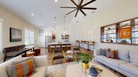 Located at 61 Grove Cir in Lillington, NC, this single-floor community space at The Groves offers a thoughtfully designed layout that balances social, functional, and wellness needs. The entrance welcomes visitors with hardwood-style flooring, large windows, and comfortable seating, setting an inviting tone throughout.

The expansive open-concept kitchen and living room serves as the heart of the space. Soaring vaulted ceilings with a dramatic oversized ceiling fan create an airy, grand atmosphere. The kitchen is outfitted with stainless steel appliances including a French door refrigerator, white cabinetry, a large island with bar seating, open wood shelving on shiplap walls, and pendant lighting. The adjoining living area features multiple seating arrangements, a built-in wood display shelf, and abundant natural light from surrounding windows.

The dedicated office provides a more intimate setting with carpeted flooring, crown molding, a round marble-top conference table, open metal shelving, and a glass-paneled door for privacy without sacrificing openness.

The exercise room is well-equipped with multiple treadmills, stationary bikes, a cable machine, free weights, and exercise balls. Rubber flooring, full-wall mirrors, large windows, and a ceiling fan ensure a comfortable and functional workout environment. Together, these spaces form a cohesive, modern, and highly functional community facility.
