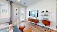 Located in Phoenix, AZ, this well-appointed one-bedroom, one-bathroom home offers a smart, efficient layout with modern finishes throughout. The open-concept kitchen and living area serves as the heart of the home, featuring crisp white shaker cabinetry, quartz countertops, a full suite of stainless steel appliances including a dishwasher and French door refrigerator, and a central island with seating — ideal for casual dining and entertaining. Wood-look flooring runs throughout the space, adding warmth and continuity.

The living room is bright and welcoming, with dual corner windows that flood the space with natural light and offer views of the surrounding neighborhood. A ceiling fan and wall-mounted TV area complete the functional design of this versatile room.

The bedroom is a serene retreat, accented by a soft blue feature wall, a ceiling fan, and a generous window with outdoor views. A dedicated closet and additional storage provide practical organization. The bathroom is finished in a clean, contemporary style with a white vanity, quartz countertop, sliding glass shower enclosure, and warm wood-tone open shelving for added character.

A hallway connects the rooms efficiently, and the home also features access to an outdoor patio space, extending the living area outdoors.
