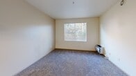Located at 875 Cinnabar St in San Jose, California, this one-bedroom, one-bathroom unit offers a practical and well-organized single-floor layout. The kitchen is outfitted with light wood cabinetry, granite-style countertops, and black appliances including a refrigerator, electric range, and dishwasher. A skylight-style overhead fixture brightens the space, and the hardwood-style flooring extends seamlessly into the adjacent living area, which is illuminated by a hanging pendant light. The living room features plush carpeting and a sliding glass door that opens onto a private balcony with wooded views, bringing in natural light and a connection to the outdoors. The bedroom is a comfortable size, featuring soft carpet, a sliding-door closet, and a window with views of surrounding greenery. A wall-mounted HVAC unit provides climate control. The bathroom includes a wood-vanity with under-sink storage, a mirrored medicine cabinet, and a full bathtub with shower, all set on hardwood-style flooring. Additional conveniences include a dedicated laundry area, hallway, and closet. The unit's neutral color palette and functional design create a clean, move-in-ready environment well-suited for everyday living in the heart of San Jose.
