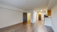 Located on the third floor at 2201 4th Avenue in Seattle's Belltown neighborhood, this studio unit offers a well-designed, efficiently laid-out living space. The open-plan main area seamlessly integrates the living, dining, and kitchen zones, all finished with warm wood-style plank flooring that runs throughout the unit. A large window in the living area allows natural light to fill the space while framing views of the surrounding urban streetscape.

The kitchen is equipped with stainless steel appliances, including a refrigerator, electric range, built-in microwave, and dishwasher. Light wood cabinetry provides ample storage, complemented by a dark laminate countertop and a stainless steel sink. A skylight above the kitchen corridor adds additional brightness to the space.

The bathroom features a full tub-shower combination with white tile surround, a vanity with a stone-look countertop, a large mirror, and wood-style flooring that coordinates with the rest of the unit.

Storage is well-addressed with two closets — one spacious walk-in closet fitted with wire shelving systems and a second closet with additional shelving. The unit's clean white walls, modern finishes, and efficient layout create a functional and contemporary living environment suited for urban living.