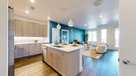Located at 2820 Hibiscus Ave in Boulder, Colorado, this well-appointed two-bedroom, two-bathroom residence offers a thoughtfully designed single-floor layout with modern finishes throughout. The open-concept living and kitchen area serves as the heart of the home, where warm wood-look flooring, recessed lighting, and a bold teal accent wall create a vibrant yet inviting atmosphere. The gourmet kitchen is a standout feature, showcasing light wood cabinetry extending to the ceiling, a large center island with seating for three, quartz countertops, stainless steel appliances, and elegant pendant lighting. A pantry provides additional storage convenience. The living room flows naturally toward a private balcony, with large windows inviting ample natural light. Both bedrooms are carpeted and tranquil, each offering generous closet space and windows with outdoor views. The primary bedroom is spaciously sized and connects to an en-suite bathroom featuring a glass-enclosed walk-in shower, wood-tone vanity, and an adjoining walk-in closet. The second bathroom offers a tub-shower combination with subway tile surround and matching vanity finishes. An in-unit laundry area adds everyday practicality to this polished Boulder home.