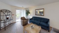 This single-floor residence in Oak Creek, Wisconsin offers a well-organized and comfortable layout across its living spaces. The living room serves as the heart of the home, featuring carpeted flooring, a sliding glass door that opens to an outdoor view, and ample room for seating — creating a bright and welcoming atmosphere. Adjacent to the living room is a cozy dining area with a ceiling fan and window overlooking the outdoors, providing a pleasant setting for meals. The galley-style kitchen is efficiently designed with warm oak cabinetry, generous counter space, tile flooring, and white appliances including a range, refrigerator, microwave, and dishwasher. The primary bedroom is a restful retreat with plush carpeting, natural light from a window, and room for a sitting area. A second bedroom also features carpeted floors, a window with outdoor views, and comfortable proportions. Two bathrooms serve the home: one with a walk-in glass-door shower, tile flooring, and wood-toned cabinetry, and another with a wide vanity, large mirror, and a shower-tub combination. Throughout the residence, neutral tones and consistent finishes contribute to a cohesive and livable environment.