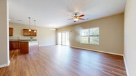 Located at 1840 Glover Ct in Independence, Kentucky, this well-appointed 2-bedroom, 2-bathroom home offers a comfortable and functional single-level layout. The open-concept kitchen and living room serve as the heart of the home, filled with natural light from large windows and a sliding glass door that leads to the patio. The kitchen is outfitted with rich wood cabinetry, granite countertops, stainless steel appliances, recessed lighting, and a central island with pendant lights — ideal for both cooking and entertaining. The living area features hardwood-style flooring and a ceiling fan, creating a bright and airy atmosphere with outdoor views. The spacious primary bedroom includes a ceiling fan, a large window overlooking the yard, and access to a well-appointed bathroom with granite vanity countertops and wood cabinetry. The second bedroom is carpeted with a built-in closet. A dedicated laundry area, a walk-in closet, and an attached garage add everyday convenience. The hallway connects all rooms with a clean, neutral palette throughout. A patio extends the living space outdoors, overlooking a generously sized yard with mature trees — completing this move-in-ready home.