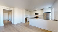 Located at 17249 N 7th St in Phoenix, AZ, this single-story home offers six bedrooms and two bathrooms within a thoughtfully designed floor plan. Light wood flooring runs consistently throughout the entire space, creating a cohesive and bright aesthetic. The open-concept kitchen and living area serves as the heart of the home, featuring white flat-panel cabinetry extending to the ceiling, a white subway tile backsplash, gray quartz countertops, a central island, and a full suite of stainless steel appliances including a range, microwave, dishwasher, and refrigerator. The adjoining living area is spacious and airy, highlighted by a ceiling fan and a sliding glass door that fills the room with natural light. The six bedrooms maintain a clean, minimalist design with white walls, ceiling fans, and ample closet space. Windows fitted with vertical blinds allow for natural light and privacy control. The two bathrooms are finished with modern white vanities, mirror-front medicine cabinets, gray countertops, and clean white shower enclosures with brushed gold fixtures. A connecting hallway ties all rooms together efficiently. The overall ambiance is modern, bright, and move-in ready.