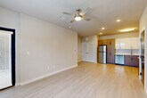 Located at 9815 Almeda Genoa Rd in Houston, TX, this single-story 2-bedroom, 2-bathroom residence offers a thoughtfully designed layout with modern finishes throughout. Light-toned luxury vinyl plank flooring runs through the main living areas, while plush carpet adds comfort to both bedrooms. The open-concept living and dining area is bright and welcoming, featuring ceiling fans, recessed lighting, and windows that invite natural light. A sliding glass door provides additional access and further brightens the living space.

The kitchen is a standout feature, showcasing a two-tone cabinet design with sleek white upper cabinets and warm wood-grain lower cabinets, complemented by white countertops and a tile backsplash. Stainless steel appliances — including a refrigerator, range, microwave, and dishwasher — complete this functional and stylish space.

Both bedrooms are generously proportioned, with the primary bedroom offering a comfortable retreat with a ceiling fan and direct access to a private bathroom. The bathrooms are finished with large-format gray tile surrounds in the tub/shower combinations and clean white cabinetry. Additional conveniences include dedicated closets, a laundry area, a utility room, and a connecting hallway that ties the layout together cohesively.