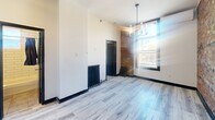 Located at 260 Sherbourne Street in Toronto's vibrant downtown east side, this one-bedroom, one-bathroom unit offers a thoughtful blend of historic character and modern updates. The main living area is bright and open, featuring light wood-style laminate flooring, tall ceilings, and a large window that draws in natural light. A striking exposed brick accent wall adds warmth and texture, while a decorative cast iron radiator serves as a functional nod to the building's heritage. An elegant pendant chandelier completes the living space.

The kitchen is efficiently designed with white shaker-style cabinetry, subway tile backsplash, a stainless steel refrigerator, and a stainless steel stove and oven — providing a clean, contemporary feel. The compact bedroom continues the light flooring and neutral palette, with its own cast iron radiator and a window allowing natural light.

The bathroom features classic white subway tile surround on the tub and shower combination, chrome fixtures, and a small window for ventilation. Throughout the unit, the consistent use of light tones, modern black trim accents, and preserved heritage elements create a cohesive and characterful living environment well-suited for urban living in Toronto.
