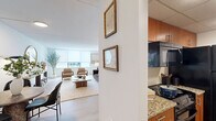 Located at 1 Franklin Town Blvd in Philadelphia's vibrant Fairmount neighborhood, this one-bedroom, one-bathroom residence offers a thoughtfully designed layout across a single floor. Light wood flooring flows throughout, lending a clean, cohesive aesthetic to the entire space.

The combined kitchen and living area serves as the heart of the home. The galley-style kitchen is well-appointed with warm wood cabinetry, granite countertops, a subway tile backsplash, and black appliances, including a full-size refrigerator and range. A set of bi-fold doors provides convenient pantry or storage access.

The living room is bright and airy, benefiting from large windows that invite natural light. The open layout accommodates distinct seating and lounge areas, creating a comfortable and versatile space for both relaxing and entertaining.

The bedroom is a calm retreat, featuring light-filled windows, light wood flooring, and ample room for a full furniture arrangement. A dedicated closet provides generous storage.

The bathroom is finished with matching granite-topped wood vanity cabinetry, a large mirror, and a tub-shower combination with tile surround. A hallway connects the rooms efficiently, completing the functional floor plan of this well-designed Philadelphia residence.