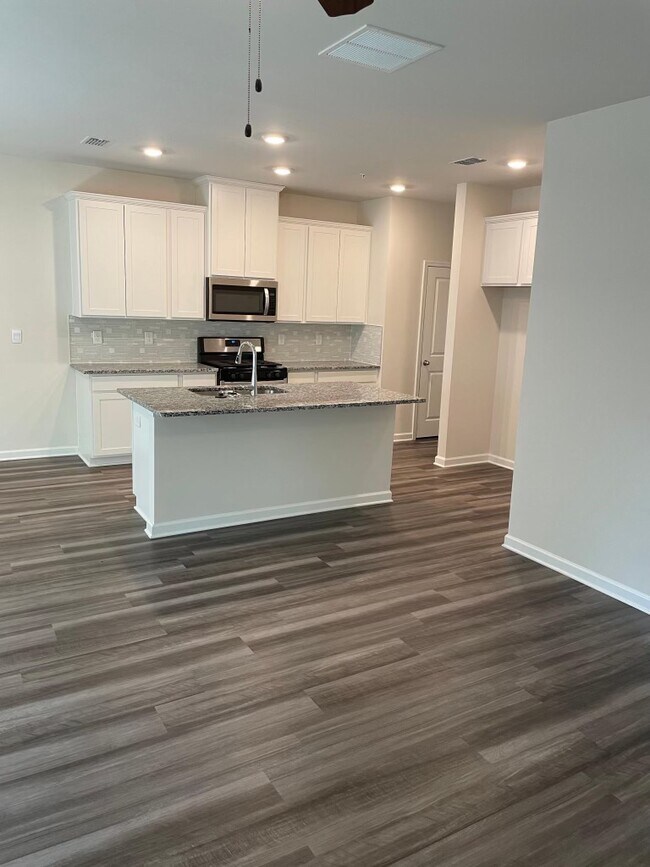 Spacious kitchen with breakfast bar open to dining and living spaces. - 1082 Arrowlake Rd