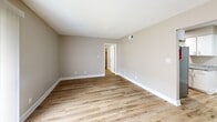 Located at 1200 W Martintown Rd in North Augusta, SC, this single-story 1-bedroom, 1-bathroom unit offers a practical and well-maintained layout with modern updates throughout. The living room serves as the central gathering space, featuring light luxury vinyl plank flooring, neutral warm-toned walls, and a sliding glass door dressed with vertical blinds that allows natural light to fill the room. The galley-style kitchen is efficiently designed with white cabinetry lining both sides, granite-patterned countertops, a stainless steel sink, and a full-size refrigerator, providing ample storage and prep space. A door at the end of the kitchen leads to additional utility access. The spacious primary bedroom is generously proportioned and features the same LVP flooring, a ceiling fan with light fixture, and a window fitted with horizontal blinds that brings in natural light. The clean, bright bathroom includes a full tub and shower combo with white surround panels and chrome fixtures. Consistent neutral paint tones, white trim, and updated flooring create a cohesive and move-in-ready aesthetic throughout the entire home.