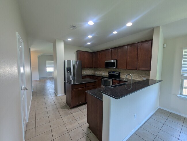 Cocina con refrigerador, estufa, horno/estufa e isla. - 2853 Waterfall Ln