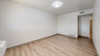 Located at 701 E Pennington St in West Burlington, Iowa, this single-floor, one-bedroom, one-bathroom unit offers a clean and functional layout designed for comfortable everyday living. Light wood-look flooring runs consistently throughout the space, complemented by crisp white walls and textured ceilings that give each room a bright, neutral aesthetic.

The combined kitchen and living area serves as the heart of the unit. The kitchen is outfitted with white shaker-style cabinetry, granite-look countertops, stainless steel appliances including an electric range and refrigerator, and ample counter space. A wall-mounted window unit provides climate control in the living area, which receives natural light through a window overlooking the surroundings.

The bedroom is a well-proportioned private retreat with a window that lets in natural light, and it connects directly to a dedicated closet with built-in shelving, providing organized storage. Additional doors off the bedroom offer access to other areas of the unit, reinforcing a practical flow throughout the layout.

The bathroom is straightforward and functional, featuring a full tub-shower combination with a white surround, updated fixtures, and wood-look flooring that ties into the rest of the unit. Overall, the space presents a tidy, move-in-ready environment with a consistent modern-neutral design throughout.