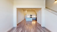 This well-appointed two-story residence showcases a thoughtful blend of modern design and classic architectural charm. Hardwood-style flooring flows throughout the main living areas, complemented by crisp white walls and an abundance of natural light streaming through generously sized windows.

The open-concept kitchen is a true centerpiece, featuring vaulted ceilings that amplify the sense of space, light gray and white cabinetry, granite-style countertops, a large central island with a sink, and a full suite of stainless steel appliances including a French door refrigerator, range, microwave, and dishwasher. Elegant pendant lighting adds warmth to the space.

Distinctive arched doorways and niches are found throughout, lending the home a refined architectural character. The bright entryway greets you with soaring ceilings and a staircase leading to the upper level. Upper-floor rooms benefit from natural views of the surrounding landscape through large arched windows, and ceiling fans provide comfort throughout.

Bedrooms are carpeted for warmth and include a spacious walk-in closet with built-in shelving and hanging rods. Bathrooms are finished with granite-topped vanities, white cabinetry, and wood-look tile flooring. The overall ambiance is clean, airy, and move-in ready.