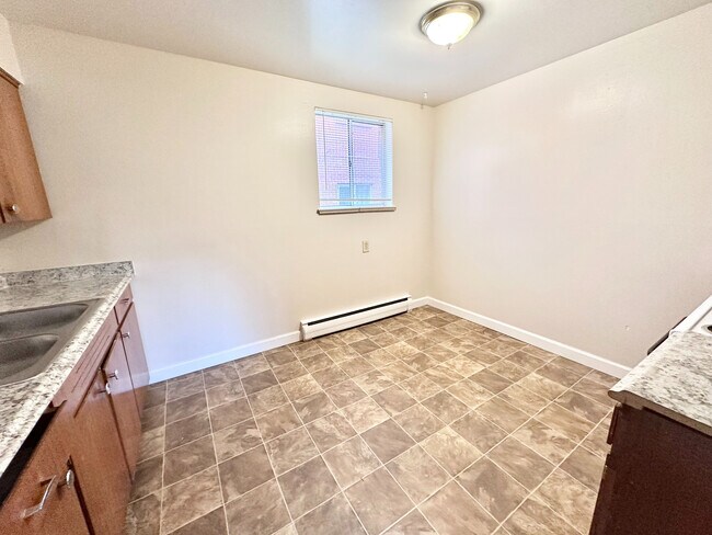 Cocina luminosa y acogedora con nuevas encimeras de granito y pisos de baldosas, perfecta para cocinar y entretener. - 7250-7290 Newton Street