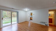Located at 9b Hudson Harbour Dr in Poughkeepsie, NY, this single-floor residence offers a practical and comfortable layout across a well-organized floor plan. The main living area is bright and open, featuring warm hardwood flooring and a sliding glass door that invites natural light while providing direct access to the outdoors and views of the surrounding greenery. A tiled entryway near the front door adds a welcoming transition into the space.

The kitchen is efficiently designed with warm oak cabinetry, dark granite-style countertops, a tiled floor, and white appliances including an electric range and dishwasher. A tiled backsplash behind the range adds a clean, finished look to the cooking area.

The bedrooms continue the hardwood flooring theme, with wide windows that frame outdoor views of the neighborhood and natural surroundings. One bedroom features carpeting, offering a softer underfoot feel. Each room is finished with crisp white walls and ceiling-mounted ventilation, maintaining a clean and neutral aesthetic throughout.

The bathroom is straightforward and functional, equipped with a full tub-and-shower combination, built-in shelving, and clean white fixtures. Overall, this single-story residence offers a cohesive, low-maintenance living environment with consistent finishes and pleasant natural light throughout.