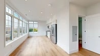 Located in Washington, DC's vibrant Capitol Hill neighborhood, this two-floor residence at 716 L St SE combines modern design with clean, functional finishes throughout. The open-concept main living area is anchored by large grid-pane windows that flood the space with natural light and offer treetop and cityscape views. Light hardwood flooring flows seamlessly through the living and dining areas, enhancing the bright, airy atmosphere created by recessed lighting overhead.

The kitchen is well-appointed with sleek white cabinetry extending to the ceiling, a neutral tile backsplash, quartz countertops, and a full suite of stainless steel appliances including a gas range, built-in microwave, dishwasher, and French door refrigerator. A black matte faucet adds a contemporary accent to the undermount sink.

The primary bathroom showcases refined craftsmanship, featuring a dual-sink vanity with warm wood cabinetry, gold hardware accents, white quartz countertops, and backlit mirrors. Large-format white tile flooring and a glass-enclosed shower contribute to its spa-like feel. Additional bedrooms are generously sized, each featuring hardwood floors, recessed lighting, and windows with neighborhood views. One bedroom provides direct access to a private outdoor terrace, offering a rare outdoor retreat within the city.