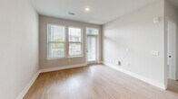 Located at 5306 Acadia Heights Dr in Charlotte, NC, this thoughtfully designed one-bedroom, one-bathroom residence offers a clean, modern aesthetic across a single level. Light hardwood-style flooring flows consistently throughout the space, complementing the neutral gray-toned walls and crisp white trim found in every room.

The open-concept kitchen and living area serves as the heart of the home. The kitchen is well-appointed with gray shaker-style cabinetry, granite countertops, a white subway tile backsplash, and a full suite of stainless steel appliances including a refrigerator with ice maker, range, microwave, and dishwasher. A central island with a granite surface and pendant lighting overhead adds both functionality and style.

The living area is bright and welcoming, with multiple windows fitted with blinds allowing ample natural light. A private entrance door with a transom window further enhances the light and accessibility of the main living space.

The bedroom is a comfortable, well-lit retreat featuring two windows with outdoor views and a ceiling fan. An adjacent closet with built-in shelving provides convenient storage solutions.

The bathroom is finished with a dual-sink vanity featuring blue-gray cabinetry and granite countertops, a large mirror, and hardwood-style flooring that continues the cohesive design language of the home. A hallway connects all rooms efficiently, completing this well-organized and modern residence.