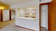 This 760 square foot apartment in Virginia Beach offers a practical and efficient living space. The unit features two bedrooms, including a primary bedroom of 160 square feet, and one full bathroom. The layout is designed for optimal use of space, with a modern kitchen as a focal point. The kitchen is equipped with white appliances, including a refrigerator and electric stove, and features ample cabinet space with a mix of upper and lower units. A pass-through window opens the kitchen to the living area, enhancing the sense of space and facilitating interaction between rooms. The bathroom includes a standard tub-shower combination with a sliding glass door, providing both functionality and a clean aesthetic. Both bedrooms are carpeted and feature built-in closets, with warm wood trim accenting the doorways and baseboards throughout the apartment. The living areas are brightened by natural light from windows, and the neutral color palette allows for personalization. This single-story apartment offers a comfortable and low-maintenance living solution, ideal for small families, couples, or roommates seeking a convenient urban lifestyle in Virginia Beach.