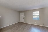 Located at 6042 N Lee St in Morrow, GA, this two-story home offers a practical and comfortable layout across two well-proportioned floors. The main level welcomes you into a bright living room featuring durable wood-look flooring and neutral-toned walls, with a window that brings in natural light. The adjacent combined dining and kitchen area is well-equipped, featuring warm wood cabinetry, a tile backsplash, stainless steel appliances including a refrigerator and range, and a dishwasher. A sliding glass door in the dining area opens to a view of the backyard, allowing additional natural light to fill the space. The main level also includes closets and convenient access to the staircase leading to the upper floor. Upstairs, the two bedrooms offer plush carpeted flooring and ceiling fans for year-round comfort. The generously sized primary bedroom includes dual closets, providing ample storage. Both full bathrooms are clean and functional, with one featuring a tub/shower combination. A hallway, additional closets, and a utility room round out the layout, offering practical storage throughout. Textured ceilings are present throughout the home, adding a classic finishing detail to the overall interior.
