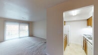 Located at 130 Rutledge Dr in Salem, Virginia, this single-floor unit offers a straightforward, functional layout designed for comfortable everyday living. The living area is generously proportioned, finished with neutral-toned wall-to-wall carpeting and a sliding glass door that allows natural light to fill the space while providing outdoor access. A ceiling fan adds to the room's practicality. The entryway transitions from tile flooring into the carpeted main living space, creating a clear delineation upon entry.

The kitchen is positioned adjacent to the living area and features warm wood cabinetry, dark laminate countertops, tile flooring, and white appliances including a gas range with overhead ventilation and a full-size refrigerator. A built-in skylight above adds brightness to the cooking space.

The unit includes multiple bedrooms, each carpeted and finished with neutral walls and window blinds that allow for natural light and privacy. One bedroom is notably more spacious, while additional rooms offer comfortable, versatile space suitable for various uses.

Two bathrooms serve the unit, each featuring a full tub and shower combination. One bathroom includes classic white tile surround, while the other presents a clean, all-white molded surround. Both are finished with white fixtures throughout, maintaining a clean and consistent aesthetic across the home.