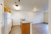 Located at 2224 Golfside Rd in Ypsilanti, MI, this two-bedroom, one-bathroom unit offers a thoughtfully arranged single-floor layout that maximizes functionality. The open-concept kitchen and living area serves as the heart of the home, featuring warm honey-toned wood cabinetry, a peninsula with a double stainless steel sink, light gray laminate countertops, and white appliances including a range and refrigerator. Wood-style vinyl flooring runs throughout the main living areas, lending a clean and cohesive look.

The living room receives natural light through a large window, creating a bright and welcoming atmosphere. Both bedrooms are well-proportioned, with the primary bedroom offering a generous closet. The secondary bedroom features neutral carpet and its own window with vertical blinds for privacy. A hallway connects the bedrooms to shared spaces, with additional closet storage accessible along the corridor.

The bathroom includes a walk-in shower with white tile surround and a stainless steel grab bar, alongside a vanity with warm wood cabinetry. Throughout the unit, neutral white walls, clean trim, and consistent flooring contribute to a simple, move-in-ready aesthetic suited for practical, comfortable living.
