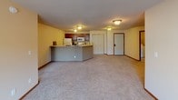 Located at 4010 Clearwater Rd in Saint Cloud, MN, this single-floor unit offers a well-organized and functional layout. The open-concept living area is spacious and carpeted, with neutral-toned walls and a sliding glass door leading to a balcony that fills the room with natural light and outdoor views. A wall-mounted air conditioning unit and baseboard heating ensure year-round comfort.

The kitchen is efficiently designed with warm cherry wood cabinetry, a full suite of white appliances including a refrigerator, electric range, microwave, and dishwasher, complemented by a peninsula counter that separates the kitchen from the living space. Tile flooring and ample cabinet storage make the kitchen both practical and attractive.

The bedrooms are carpeted and receive natural light through windows with blinds. One bedroom features two windows, offering additional brightness and views of the surrounding neighborhood.

Two full bathrooms are finished with tile flooring, cherry wood vanities, and tub-shower combinations with decorative curtains. One bathroom includes a built-in linen closet for added storage.

A dedicated in-unit laundry area houses a full-size washer and dryer with overhead shelving, providing convenient everyday functionality. Rich wood-trimmed doors and consistent finishes throughout give the space a cohesive, well-maintained character.