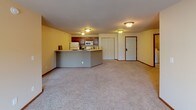 Located at 4010 Clearwater Rd in Saint Cloud, MN, this single-floor unit offers a well-organized and functional layout. The open-concept living area is spacious and carpeted, with neutral-toned walls and a sliding glass door leading to a balcony that fills the room with natural light and outdoor views. A wall-mounted air conditioning unit and baseboard heating ensure year-round comfort.

The kitchen is efficiently designed with warm cherry wood cabinetry, a full suite of white appliances including a refrigerator, electric range, microwave, and dishwasher, complemented by a peninsula counter that separates the kitchen from the living space. Tile flooring and ample cabinet storage make the kitchen both practical and attractive.

The bedrooms are carpeted and receive natural light through windows with blinds. One bedroom features two windows, offering additional brightness and views of the surrounding neighborhood.

Two full bathrooms are finished with tile flooring, cherry wood vanities, and tub-shower combinations with decorative curtains. One bathroom includes a built-in linen closet for added storage.

A dedicated in-unit laundry area houses a full-size washer and dryer with overhead shelving, providing convenient everyday functionality. Rich wood-trimmed doors and consistent finishes throughout give the space a cohesive, well-maintained character.
