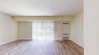Located at 736 Stanford Court in Edgewood, Maryland, this two-story home offers a practical and functional layout spread across two floors. The main level features a bright and open living room with large sliding glass doors fitted with vertical blinds, allowing generous natural light and outdoor views. The kitchen is well-appointed with warm wood-toned cabinetry, white appliances including a range, microwave, dishwasher, and refrigerator, along with ample counter space and a window overlooking the outdoors. The kitchen also accommodates an in-unit washer and dryer, adding everyday convenience. Consistent wood-look flooring flows throughout the main living areas, giving the home a cohesive and clean aesthetic. The upper floor houses all three bedrooms, including a spacious primary bedroom, each finished with the same wood-look flooring. The secondary bedrooms feature windows that bring in natural light, and select bedrooms include closets for storage. Two bathrooms serve the home, one of which features a wood-toned vanity with a white countertop and a mirror. A hallway with a staircase connects both floors. Neutral wall tones throughout lend the home a clean, move-in-ready feel.