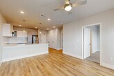 Located at 4854 Greenhouse Rd in Houston, TX, this 1-bedroom, 1-bathroom unit offers a thoughtfully designed single-floor layout that maximizes functionality and comfort. The open-concept living and dining area is bright and welcoming, featuring light hardwood-style flooring, recessed lighting, and a ceiling fan. A glass door and large windows invite ample natural light and provide outdoor views, enhancing the airy atmosphere throughout.

The kitchen is well-appointed with two-tone cabinetry — white upper cabinets and gray lower cabinets — complemented by a white countertop, a stainless steel refrigerator, gas range, and built-in microwave. A kitchen island adds additional prep and counter space.

The bedroom is generously sized, finished with plush carpet, a ceiling fan, and windows that allow natural light. It connects to a spacious walk-in closet with wrap-around shelving and additional carpet flooring. The bathroom features a dual-sink vanity with gray cabinetry, a white countertop, and a large mirror with overhead lighting. A dedicated laundry area and utility room provide added convenience. The hallway connects all spaces efficiently, completing this well-organized and modern unit.