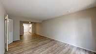 Located at 2100 Rebsamen Park Rd in Little Rock, Arkansas, this well-appointed one-bedroom, one-bathroom residence offers a comfortable and functional single-floor layout. The open living area is finished with durable wood-look flooring and neutral-toned walls, creating a bright and welcoming atmosphere. A ceiling fan adds comfort, while sliding glass doors with vertical blinds invite natural light and provide access to the outdoors. The galley-style kitchen is thoughtfully designed with white shaker cabinetry, light granite-style countertops, a stainless steel refrigerator, a gas range, a dishwasher, and a stainless steel sink — all illuminated by a skylight overhead. The kitchen flows directly into the living area, making the space feel connected and open. The bedroom features plush carpeting, a ceiling fan with light fixture, and a window overlooking the outdoors. It connects to a generously sized walk-in closet with built-in shelving and hanging rods, offering ample storage. The bathroom includes a tiled tub-shower combination, a white vanity, and a window for natural ventilation. Wood-look flooring carries through the main living areas, unifying the overall design with a clean, modern aesthetic.