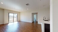 Located in the Hollywood Hills area of Los Angeles, this single-floor residence at 6900 Bonita Terr offers a clean, modern aesthetic throughout. Rich hardwood-style flooring runs continuously across the main living areas, anchoring the open-concept layout and creating a warm, cohesive feel.

The spacious living area is bathed in natural light from a large sliding glass door that opens to a private balcony with views of the surrounding Los Angeles neighborhood. Recessed lighting overhead adds a polished finish to the bright, neutral-toned walls.

The kitchen is well-appointed with dark espresso cabinetry, white countertops, a classic subway tile backsplash, and a full suite of stainless steel appliances including a gas range, over-the-range microwave, and refrigerator. A built-in pantry with open shelving provides generous storage.

The bedrooms are generously sized, each featuring hardwood-style flooring, neutral walls, and ample natural light. One bedroom includes sliding closet doors, while another benefits from multiple windows with views of mature palm trees. Wall-mounted sconce lighting adds a refined touch to the hallway areas.

The bathrooms are finished with clean, white subway tile, a soaking tub, and a separate bathroom featuring tile flooring, a dark wood vanity, and a window for natural ventilation. This residence offers a thoughtfully designed, move-in-ready living experience in a prime Los Angeles location.