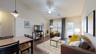 Located at 2900 Old US Highway 63 S in Columbia, Missouri, this single-floor residence offers a thoughtfully designed layout with comfortable living spaces throughout. The open living and dining area is anchored by rich hardwood-style flooring, a ceiling fan, and large windows dressed with gray curtains that invite an abundance of natural light. A private exterior door leads to an outdoor space, enhancing the sense of openness. The kitchen is well-equipped with stainless steel appliances, including a range, dishwasher, and refrigerator, complemented by light wood cabinetry and generous countertop space. Multiple bedrooms provide comfortable retreats, each featuring hardwood-style flooring, ceiling fans, and windows that bring in natural light. The bedrooms offer ample room for sleeping and study areas. Two bathrooms serve the residence, each outfitted with wood-toned vanities, hardwood-style flooring, and shower/tub combinations. A dedicated laundry room houses a full-sized washer and dryer with additional wire shelving for storage. Throughout the home, neutral wall tones and consistent flooring create a cohesive and functional living environment well-suited for everyday comfort.