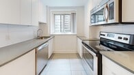 Located at 3435 Rue Drummond in the heart of downtown Montréal, this well-appointed 3-bedroom, 2-bathroom unit offers a thoughtfully designed single-floor layout. The open living area is bathed in natural light, featuring warm hardwood floors and large sliding glass doors that lead to a private balcony overlooking the vibrant city streetscape. The galley-style kitchen is equipped with stainless steel appliances, including a refrigerator, electric range, dishwasher, and built-in microwave, complemented by sleek grey countertops, white cabinetry, and clean tile flooring. A convenient in-unit washer and dryer are tucked along the hallway corridor. The generously sized primary bedroom features sliding closet doors and hardwood flooring, while the additional bedrooms offer comparable finishes with natural light from exterior windows. The main bathroom is finished with grey tile walls, a bathtub, wall-mounted vanity, and a large mirror, while the second bathroom provides a more compact, functional layout. Throughout the unit, a neutral white palette and clean lines create a bright, modern ambiance well-suited to urban living in one of Montréal's most sought-after neighbourhoods.
