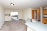 This single-floor unit offers a straightforward, functional layout across several well-defined spaces. The bedrooms are finished with neutral wall-to-wall carpeting and feature ceiling fans with light fixtures, providing both comfort and air circulation. Each bedroom is equipped with a baseboard heating unit and a window fitted with blinds, allowing natural light and views of the surrounding outdoor greenery. One bedroom includes access to a generously sized walk-in closet outfitted with multiple hanging rods and shelving, offering ample storage capacity.

The kitchen is designed for practicality, featuring warm-toned wood cabinetry that extends to the upper walls for abundant storage. Grey laminate countertops provide a neutral work surface, complemented by tile flooring. Appliances include an electric range, over-the-range microwave, refrigerator, and dishwasher.

The bathrooms are cleanly finished with tile flooring, wood vanities topped with grey countertops, and a tub-shower combination. One bathroom features a lighted vanity mirror, adding a bright, functional touch. Textured ceilings are consistent throughout the unit, contributing to its cohesive, understated aesthetic overall.