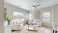 Located at 185 Rosewood Loop in Burlington, NC, this well-appointed two-bedroom, two-bathroom home offers a thoughtfully designed single-level layout. The open-concept living and kitchen area serves as the heart of the home, bathed in natural light from multiple windows dressed with white blinds. A ceiling fan adds comfort to the bright living room, which features light wood-style flooring and a neutral color palette throughout.

The kitchen is a standout space, showcasing white shaker cabinetry, granite countertops, and stainless steel appliances including a refrigerator, range, and built-in microwave. A large granite-topped island with bar seating and pendant lighting above makes it ideal for both cooking and casual dining.

Both bathrooms continue the home's design consistency with white cabinetry, granite vanity tops, and wood-style flooring. One bathroom features a shower with a curtain, while the other includes a tub-shower combination.

The two bedrooms offer comfortable, carpeted retreats. The primary bedroom receives generous natural light through a large window and includes closet space. The second bedroom also features a closet and a warm, restful atmosphere. Multiple hallways connect the spaces efficiently, completing this clean, modern home.