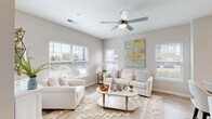 Located at 185 Rosewood Loop in Burlington, NC, this well-appointed two-bedroom, two-bathroom home offers a thoughtfully designed single-level layout. The open-concept living and kitchen area serves as the heart of the home, bathed in natural light from multiple windows dressed with white blinds. A ceiling fan adds comfort to the bright living room, which features light wood-style flooring and a neutral color palette throughout.

The kitchen is a standout space, showcasing white shaker cabinetry, granite countertops, and stainless steel appliances including a refrigerator, range, and built-in microwave. A large granite-topped island with bar seating and pendant lighting above makes it ideal for both cooking and casual dining.

Both bathrooms continue the home's design consistency with white cabinetry, granite vanity tops, and wood-style flooring. One bathroom features a shower with a curtain, while the other includes a tub-shower combination.

The two bedrooms offer comfortable, carpeted retreats. The primary bedroom receives generous natural light through a large window and includes closet space. The second bedroom also features a closet and a warm, restful atmosphere. Multiple hallways connect the spaces efficiently, completing this clean, modern home.