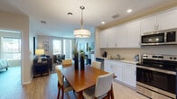 Located in the vibrant North Park neighborhood of San Diego, this well-appointed single-floor residence offers a thoughtfully designed open-concept layout that seamlessly connects the kitchen, dining, and living areas. The kitchen is outfitted with crisp white shaker cabinets, light countertops, and a full suite of stainless steel appliances, including a side-by-side refrigerator, electric range, over-the-range microwave, and dishwasher. Light hardwood-style flooring flows throughout, adding warmth and continuity to the space. The dining area is anchored by a rich wood table beneath a stylish drum pendant light, creating an inviting setting for meals and gatherings. The living room is bright and welcoming, featuring large sliding glass doors that open to a private balcony with outdoor views, allowing abundant natural light to fill the space. The bedroom is a serene retreat, featuring large windows with neighborhood views, ample storage, and a calm, neutral color palette accented by soft teal tones. The bathroom is clean and functional, finished with white tile, a soaking tub with shower, and a white vanity with generous mirror. Throughout the residence, recessed lighting, neutral walls, and consistent finishes contribute to a cohesive, modern ambiance.
