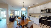 Located in the vibrant North Park neighborhood of San Diego, this well-appointed single-floor residence offers a thoughtfully designed open-concept layout that seamlessly connects the kitchen, dining, and living areas. The kitchen is outfitted with crisp white shaker cabinets, light countertops, and a full suite of stainless steel appliances, including a side-by-side refrigerator, electric range, over-the-range microwave, and dishwasher. Light hardwood-style flooring flows throughout, adding warmth and continuity to the space. The dining area is anchored by a rich wood table beneath a stylish drum pendant light, creating an inviting setting for meals and gatherings. The living room is bright and welcoming, featuring large sliding glass doors that open to a private balcony with outdoor views, allowing abundant natural light to fill the space. The bedroom is a serene retreat, featuring large windows with neighborhood views, ample storage, and a calm, neutral color palette accented by soft teal tones. The bathroom is clean and functional, finished with white tile, a soaking tub with shower, and a white vanity with generous mirror. Throughout the residence, recessed lighting, neutral walls, and consistent finishes contribute to a cohesive, modern ambiance.