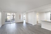 This single-floor unit offers a thoughtfully designed open layout with clean, modern finishes throughout. The living area is bright and welcoming, featuring light hardwood-style flooring, neutral-toned walls, and a sliding glass door that opens to a private balcony, allowing natural light to flow freely into the space. An additional window in the bedroom area further enhances the sense of openness with views of surrounding greenery.

The kitchen is a standout feature, boasting crisp white cabinetry, a granite-style countertop with a breakfast bar peninsula, stainless steel appliances including a range, microwave, and refrigerator, and a modern matte black faucet over a double sink. The space transitions seamlessly from the kitchen into the living area, making it ideal for everyday living and entertaining.

The bedroom offers a calm, minimal retreat with ample wall space, hardwood-style flooring, and a closet. The bathroom is finished in a clean, contemporary style with a full tub-shower combination, white subway-style surround, and sleek matte black fixtures and hardware. A textured ceiling in the main living area adds a subtle architectural detail. Overall, the unit presents a fresh, move-in-ready aesthetic with a cohesive neutral palette throughout.