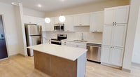 This 660 square foot apartment in Victoria, MN, is a model of efficient design and modern living. The single-floor layout comprises one bedroom, measuring 120 square feet, a combined kitchen and living room area, and a dedicated laundry space. The interior is characterized by clean lines and a bright, airy ambiance, enhanced by neutral tones and ample natural light.

The kitchen is a highlight, featuring white cabinetry, stainless steel appliances, and a central island, creating a functional and aesthetically pleasing cooking space. The living area seamlessly connects to the kitchen, offering an open-concept design ideal for entertaining or relaxation. Large windows in the living space and bedroom provide natural illumination and views of the surroundings.

The bedroom, while compact, is well-designed with plush carpeting and sufficient space for essential furnishings. The in-unit laundry area, equipped with a stacked washer and dryer, adds convenience to daily life. Throughout the apartment, modern fixtures such as recessed lighting and ceiling fans contribute to the contemporary feel.

Flooring varies between rooms, with durable wood-look flooring in the main living areas and soft carpeting in the bedroom, adding warmth and texture. The overall design prioritizes functionality without sacrificing style, making efficient use of every square foot to create a comfortable and inviting living space.