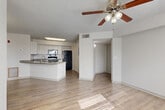 Located in Palm Bay, Florida, this one-bedroom, one-bathroom residence offers a functional and efficiently designed single-story layout. The open-concept living area seamlessly connects the living room, dining space, and kitchen, all finished with light wood-look flooring that brightens the interior. Ceiling fans throughout enhance comfort and airflow in the Florida climate. Natural light flows in through window blinds, giving the space a clean, airy feel.

The kitchen features white cabinetry, granite-style countertops, and black appliances including a refrigerator, electric range, and over-the-range microwave. A peninsula with a sink adds both prep space and a natural divider between the kitchen and living areas. A pantry provides additional storage convenience.

The bedroom is carpeted and well-sized, with a ceiling fan and a window offering natural light and outdoor views. It includes access to a spacious walk-in closet outfitted with wire shelving for organized storage.

The bathroom is clean and straightforward, featuring a full tub-shower combination and wood-look flooring. A dedicated laundry area with a stacked washer and dryer unit adds in-unit convenience. The textured ceilings are consistent throughout, complementing the home's simple, practical aesthetic.