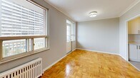 Located at 110 Marlee Avenue in Toronto's vibrant Marlee Village neighbourhood, this well-appointed 3-bedroom, 1-bathroom unit offers a practical and comfortable layout across a single floor. The warm, classic parquet wood flooring flows consistently throughout the living areas and all three bedrooms, lending a timeless character to the space. The living room is generously proportioned, featuring large windows fitted with a radiator beneath, allowing natural light to fill the room while providing an elevated view of the surrounding cityscape. Each of the three bedrooms is a well-sized, quiet retreat — the primary bedroom includes a sliding-door closet — and all bedrooms feature windows with radiator heating and views of the Toronto skyline and neighbourhood rooftops. The galley-style kitchen is efficiently designed with white cabinetry, light countertops, tile flooring, and stainless steel appliances including a refrigerator and electric range. The bathroom is clean and bright, featuring a full soaker tub with white subway tile surround and a marble-effect vanity countertop. A hallway connects the rooms seamlessly. The unit also features a private balcony offering open views of the surrounding mid-rise and high-rise Toronto neighbourhood.