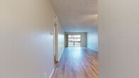 Located at 9901 Lurline Ave in the Chatsworth neighborhood of Los Angeles, this 2-bedroom, 1-bathroom single-story unit offers a well-organized layout across a comfortable footprint. The open living room is a standout feature, showcasing light hardwood-style flooring, a textured ceiling, a ceiling fan, and a large sliding glass door that leads to a private balcony overlooking greenery and mature trees. The space is bright and airy, with natural light flowing throughout.

The galley-style kitchen is thoughtfully designed with crisp white shaker cabinets, quartz-style countertops, a stainless steel sink, and a full suite of stainless steel appliances, including a range, microwave, dishwasher, and refrigerator. The clean, neutral palette gives the kitchen a modern and functional feel.

Both bedrooms feature the same light hardwood-style flooring, neutral gray walls, textured ceilings, and windows that allow natural light in. The primary bedroom is generously sized and includes a closet. The bathroom is clean and straightforward, equipped with a tub/shower combo and light wood-style flooring consistent with the rest of the home. A hallway connects all rooms, completing the efficient single-floor layout.