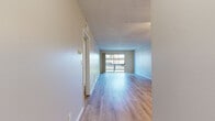 Located at 9901 Lurline Ave in the Chatsworth neighborhood of Los Angeles, this 2-bedroom, 1-bathroom single-story unit offers a well-organized layout across a comfortable footprint. The open living room is a standout feature, showcasing light hardwood-style flooring, a textured ceiling, a ceiling fan, and a large sliding glass door that leads to a private balcony overlooking greenery and mature trees. The space is bright and airy, with natural light flowing throughout.

The galley-style kitchen is thoughtfully designed with crisp white shaker cabinets, quartz-style countertops, a stainless steel sink, and a full suite of stainless steel appliances, including a range, microwave, dishwasher, and refrigerator. The clean, neutral palette gives the kitchen a modern and functional feel.

Both bedrooms feature the same light hardwood-style flooring, neutral gray walls, textured ceilings, and windows that allow natural light in. The primary bedroom is generously sized and includes a closet. The bathroom is clean and straightforward, equipped with a tub/shower combo and light wood-style flooring consistent with the rest of the home. A hallway connects all rooms, completing the efficient single-floor layout.