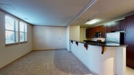This two-floor residence is thoughtfully designed with a cohesive aesthetic carried throughout both levels. The main living area is open in concept, with neutral-toned carpet underfoot and a curved kitchen peninsula separating the living space from the kitchen. The kitchen is well-appointed with rich dark wood cabinetry, dark granite countertops, stainless steel appliances including a refrigerator, microwave, and range, and tile flooring. A louvered pantry door adds a classic touch, while track lighting provides focused illumination over the workspace.

The bathrooms feature consistent finishes, including dark wood vanities with white countertops, large mirrors with multi-bulb vanity lighting, and tile flooring. One bathroom includes a full soaking tub with a tiled surround and chrome fixtures.

The upper level, accessed via a staircase with a wood banister, includes generously sized bedrooms with plush carpeting, crown molding, and ceiling fans. Bedrooms are accompanied by walk-in closets and direct access to bathrooms. Windows throughout bring in natural light and views of the surrounding area, contributing to the overall warm and functional character of the space.